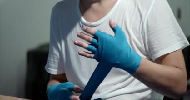 Boxing, training day, boxing gym, a male boxer puts a special bandage on his hands before the fight, a close-up of the hand of a young athlete who is preparing for a fight. — Stock Video