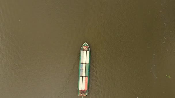 Drohne fliegt morgens über den gelben Fluss, auf dem der Containerdampfer fährt, Gütertransport auf Schiffen auf See oder Flüssen. — Stockvideo