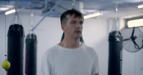 Výcvik bojovníků. Mužský boxer dělá cvičení s skákání provaz, zahřívání s kardio cvičení, detailní záběr na nohu mužského boxera skákání v tělocvičně. — Stock video
