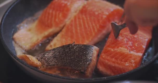 Stukjes heerlijke vis gekookt in de keuken. Schot van het koken van grote mooie stukjes rode vis bakken in kokende olie in een koekenpan, food concept. — Stockvideo