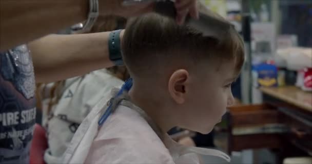 Coiffure d'enfant. Petit garçon obtient une coupe de cheveux. — Video