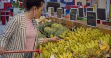 Süpermarketin bakkal bölümünde çalışan genç bir kadın yiyecek satın alıyor, insanların yiyecek satın aldığı bir konsept. Güzel bir kadın marketten yiyecek, meyve, elma, portakal alır..