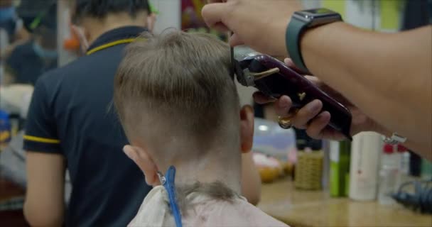 Corte de cabelo das crianças no salão no momento da epidemia de coronavírus. Pequeno menino recebe um corte de cabelo. — Vídeo de Stock