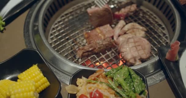 Chefe a usar o tong e a virar a carne no grelhador. O fogo está queimando, o bife de óleo suculento quente que cozinha perto acima do movimento lento. Grill, saboroso bife câmera lenta de perto. — Vídeo de Stock