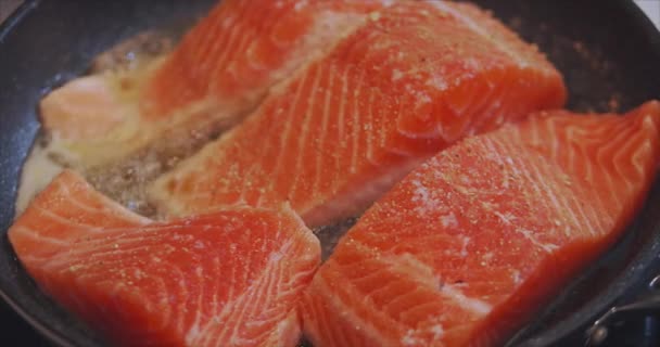 Close-up shot van het koken van grote mooie stukjes rode vis bakken in kokende olie in een koekenpan, food concept. Cijfers van heerlijke vis gekookt in de keuken — Stockvideo