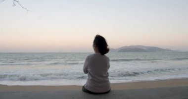 Yalnız başına koruyucu maske takan bir kadın deniz manzarasından zevk alır. Coperid-19 maskesi takar. Sağlık ve güvenlik konsepti, N1H1 koronavirüs, virüs koruması, salgın hastalık.