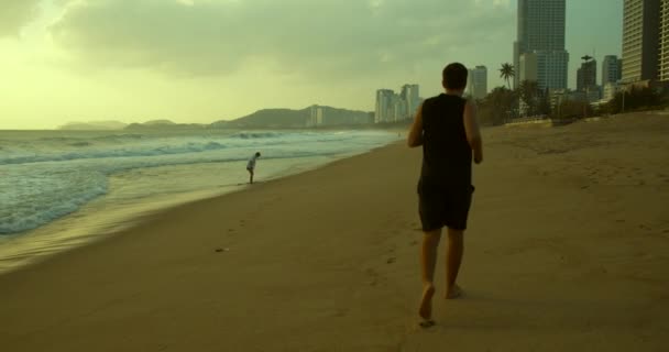 Jovem caucasin homem estão se exercitando com ao ar livre correndo com um belo fundo do mar. Homem em fuga, estilo de vida saudável. Triatleta de corrida, treinamento de resistência, sprint. — Vídeo de Stock