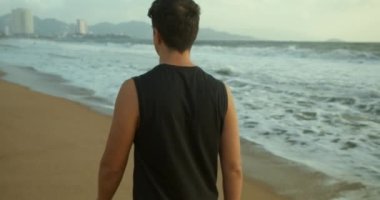 Gün batımında kumsalda yürümek güzel denizin arka planına karşı, büyük güzel dalgalar..