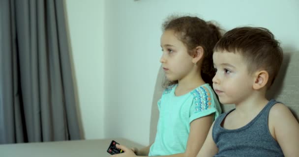 Retrato lindo niños pequeños mientras mira la televisión en el ordenador portátil. Hermano y hermana viendo la televisión. Concepto Videojuego, Entretenimiento, Emociones. — Vídeo de stock