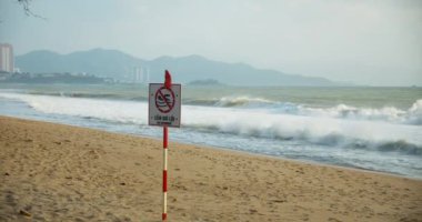 Plaj Vietnamlı gün batımı. Denizde yüzme yasağı için tablet, Asya sahili arka planı, daha fazla dalga, sakin bir denizde.