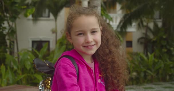 Portret Grappig meisje lachend kind kijkend naar de camera lopen op straat, schattig kind met mooi gezicht op straat. Concept van een gelukkige jeugd. — Stockvideo