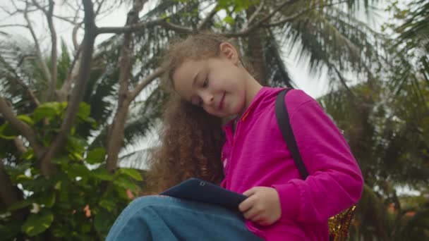 Kinderen tech verslaving concept spel te spelen. Meisje speelt in de telefoon zittend op straat alleen. — Stockvideo