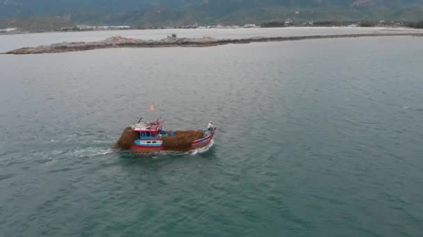 Professionelle Fischerboot kehrt in den Hafen am Morgen in der Sonne nach dem Fischen, Schießen von der Drohne eines asiatischen Fischerschoners ein Boot mit Krabbenfallen für Tintenfische und Hummer bei hoher Geschwindigkeit — Stockvideo