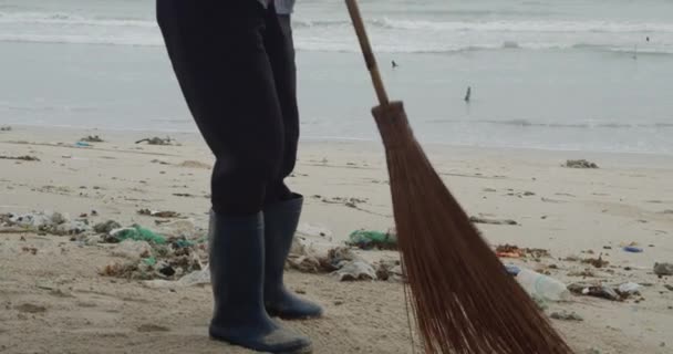 Женщина-волонтер убирает белый пляж. Доброволец поднимает и бросает пластиковый мусор в мешок. Концепция волонтерства и переработки. Концепция экологической сознательности. — стоковое видео