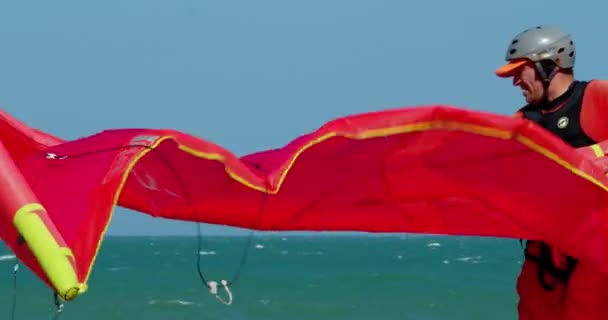 Kitesurfer förbereder sin drake innan segling i havet för att rida på vågorna i havet. Aktiva människor, kitesurfing plats, sport koncept, hälsosam livsstil. Han Hoa-provinsen, Vietnam, 22 februari 2021 — Stockvideo