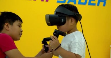 Sanal gerçeklik gözlüğü takan ve evde video izleyen bir çocuk.