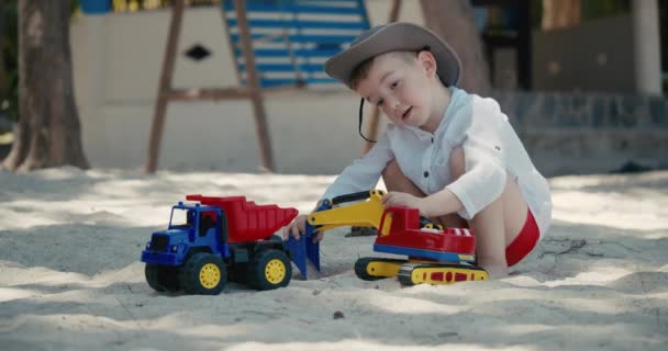 Los niños juegan con un coche de plástico en la arena de la playa. primer plano de los niños manos jugando con arena en la playa, juguetes de plástico. — Vídeos de Stock