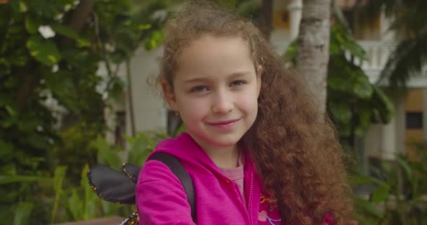 Ritratto Bambino divertente o bambina sorridente guardando la macchina fotografica camminano per strada, bambino carino con un bel viso per strada. Concetto di infanzia felice. — Video Stock