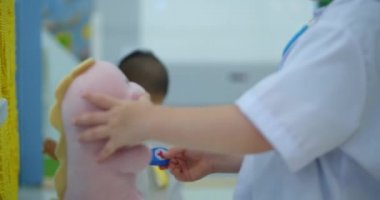 Beyaz üniforma giyen sevimli anaokulu çocuğu, evcil hayvan solunumunu, papağanları ve oyuncak hastaları dinliyor, hastane oyunu oynayan doktor, veteriner, doktor, evsizleri tedavi eden çocuk.