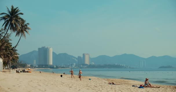 Efter isoleringskarantänen. COVID-19. Vänner spelar strand babinton i gryningen i no-turist filmisk resort i Nha Trang, Vietnam, 24 april 2021 — Stockvideo