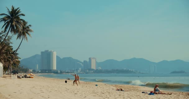 Después de la cuarentena de aislamiento. COVID-19. Amigos juegan babinton playa al amanecer en el complejo cinematográfico no turístico de Nha Trang, Vietnam, 24 de abril de 2021. — Vídeos de Stock