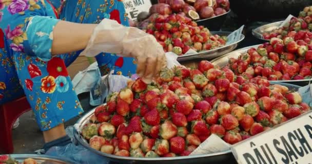 Province de Han Hoa, Vietnam, 9 mai 2021.Les vieilles femmes vietnamiennes vendent des fruits tropicaux frais, des fraises à un marché de rue dans la ville touristique, des personnes masquées au marché en raison de l'épidémie mondiale de Covid 19 — Video