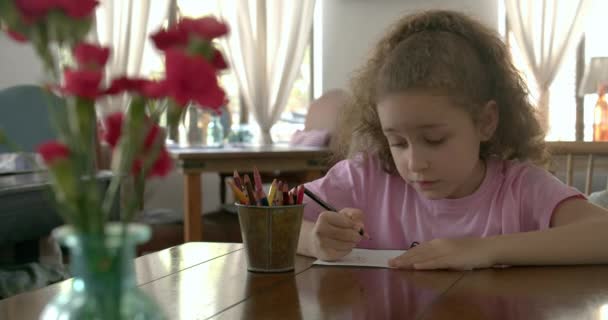 Happy Little Girl o bambino della scuola elementare carino di 7-8 anni a casa rilassarsi si siede in casa e dipinge su matite di colore uso carta. Bambino disegna, focalizzato bambini concetto di istruzione elementare. — Video Stock