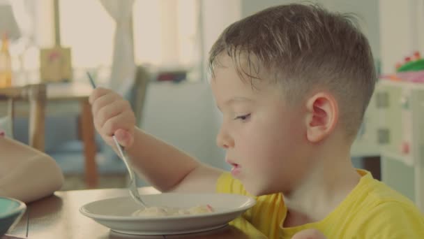 Kind dat gezond biologisch en veganistisch voedsel eet in restaurant. Gezonde kleuter jongen eet pasta miyoki zittend in kinderdagverblijf cafe. Jeugd, gezondheidsconcept. — Stockvideo