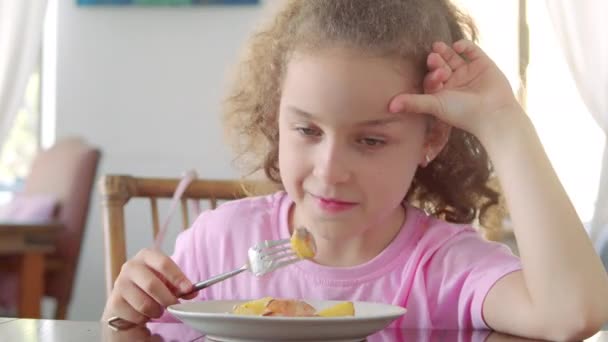 Bambino felice mangiare cibo sano biologico e vegano nel ristorante. Carino sano prescolastica ragazza mangia patate fritte con una bistecca seduta in vivaio caffè. Infanzia, concetto di salute. — Video Stock