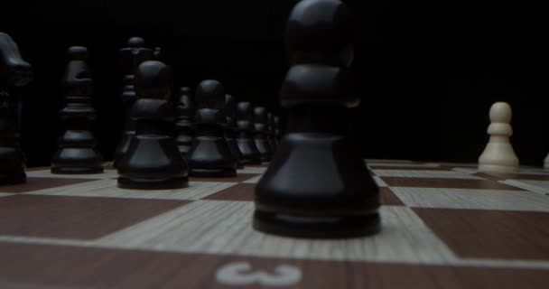 Filmed in a dark key. Confident play of the leaders.Super-macro photography of a chessboard with chess, camera travel on a slider from white pieces to black ones. Game of chess — Stock Video