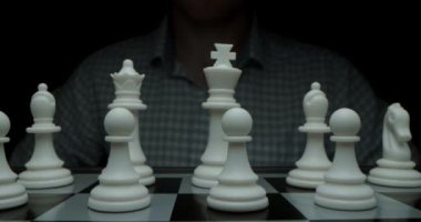 White moves with a pawn. Super-macro photography of a chessboard with chess, camera travel on a slider from white pieces to black ones.Game of chess. Filmed in a dark key.