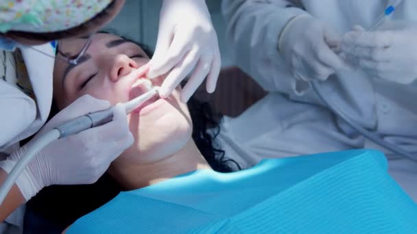 Uma jovem dentista. Nomeação com um ortodontista. Substituir um enchimento temporário por um enchimento permanente. A polir. Ligação de gel. — Vídeo de Stock