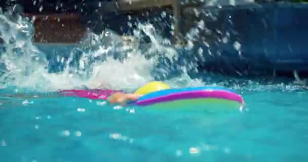 Niño con gorras de natación realiza una tarea en una lección de natación en la piscina. — Vídeos de Stock