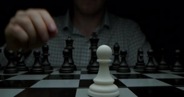 Супер-макросъемка шахматной доски с шахматами, камера перемещается на слайдере от белых фигур к черным. Снято тёмным ключом. — стоковое видео