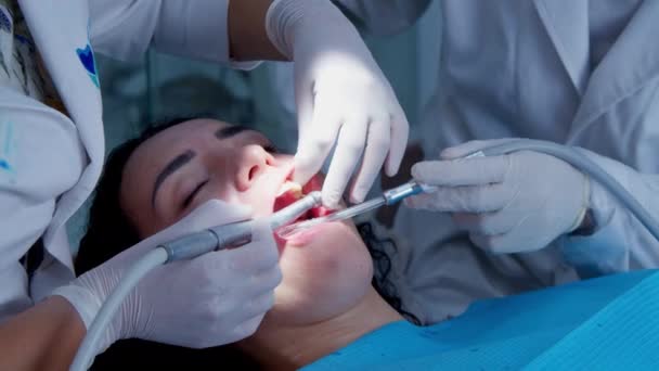 若い女性歯科医。歯医者との約束だ。一時的な充填を恒久的な充填に置き換えます。研磨だ。ゲル結合. — ストック動画