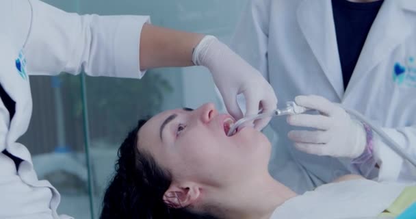 Ένας οδοντίατρος αρχειοθετεί την πλήρωση του νεαρού ασθενή του. Ραντεβού στον ορθοδοντικό. Αντικατάσταση μιας προσωρινής πλήρωσης με μια μόνιμη. στίλβωση. — Αρχείο Βίντεο