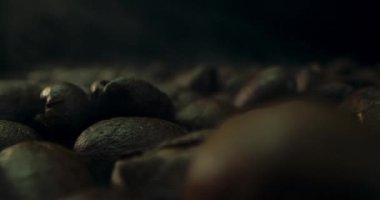 Kahve çekirdeklerini kızartırken yakın çekim, kahve çekirdeklerini kavururken çıkan dumanı siyah bir anahtarla kaydedilmiş. Aromatik Kahve Fasulyesi Konsepti.