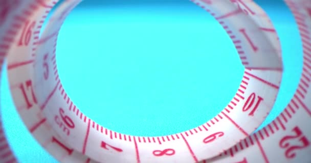 Plan super macro d'un ruban à mesurer dans un rouleau de couture et de fil coloré sur le fond bleu. Usine de vêtements. Les fils, ruban à mesurer, bobines de fils colorés sont visibles dans le cadre. — Video