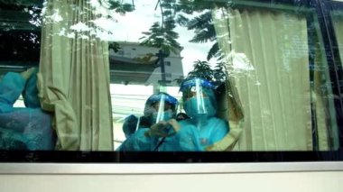 Yolcu otobüsündeki bilinmeyen bir grup insan, salgın sırasında güvenlik önlemleri nedeniyle 3 haftalık bir karantina alanına götürüldü. Koruyucu giysiler ve maskeler giyen insanlar,