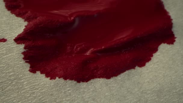 Conceito de sangue vermelho. Gotas de sangue pingam em um guardanapo de papel, o sangue se espalha sobre o guardanapo, tiro macro. — Vídeo de Stock