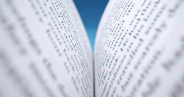 Concetto Super macro shot, primo piano delle pagine di un libro. Il libro è aperto alla lettura. L'uomo apre un libro da leggere, su sfondo blu primo piano di uno scatto una pagina di un libro. — Video Stock