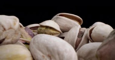 Makro mercek, fındık fıstığının siyah ve sarı arkaplandaki güzel ışıkta çok yakın çekim makrosu, fıstıklı kameraya çarpıyor.