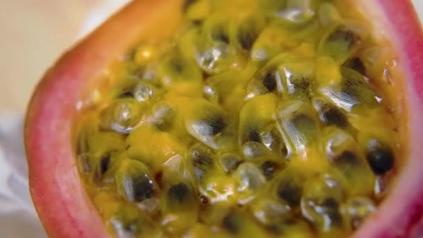 Macro shot of sliced fresh exotic passion fruit fruit rotating on a table. Slow motion video 4K — Stock Video