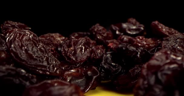 A dry grapes macro shot close-up shot of ripe raisins lies on a table against a black background. Macro close-up shot of raisins. Interesting angle, stock footage. — Stock Video