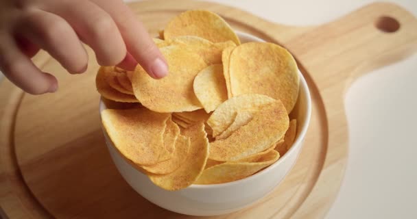 Vista superior de un tazón de papas fritas. Cierre de manos de los niños que toman las papas fritas del tazón. Vista del tazón de papas fritas desde arriba. — Vídeo de stock