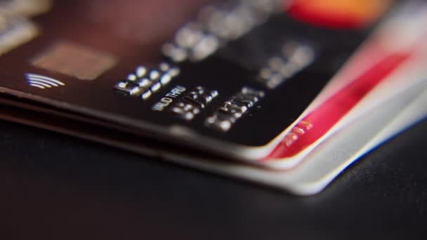 Un homme met des cartes bancaires dans une pile, des piles de cartes de crédit usagées sont disposées sur la table plans rapprochés. — Video