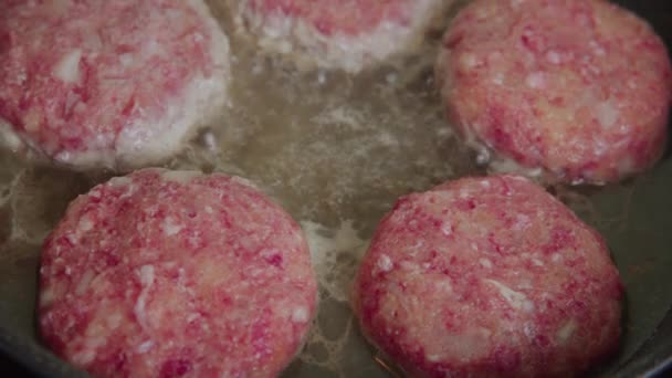 Wir kochen saftige Rind- und Schweineschnitzel für einen Burger zum Frühstück. Das Fleisch wird in der Küche in einer Grasnarbe gebraten. Zeitlupe. — Stockvideo