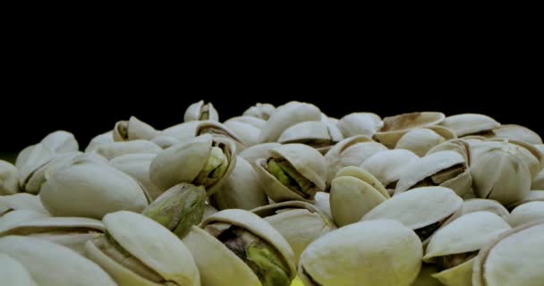 Macro lens, very close-up macro shot of a pistachio in beautiful light on a black and yellow background, hitting the camera on pistachios — Stock Video