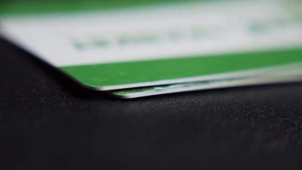 En man lägger bankkort i en hög, staplar av använda kreditkort läggs ut på bordet närbilder. — Stockvideo