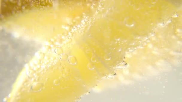 Taze limon, bir bardak köpüklü buzlu suya eklenir ve ferahlatıcı bir içecek elde edilir. Ferahlatıcı bir içecek.. — Stok video